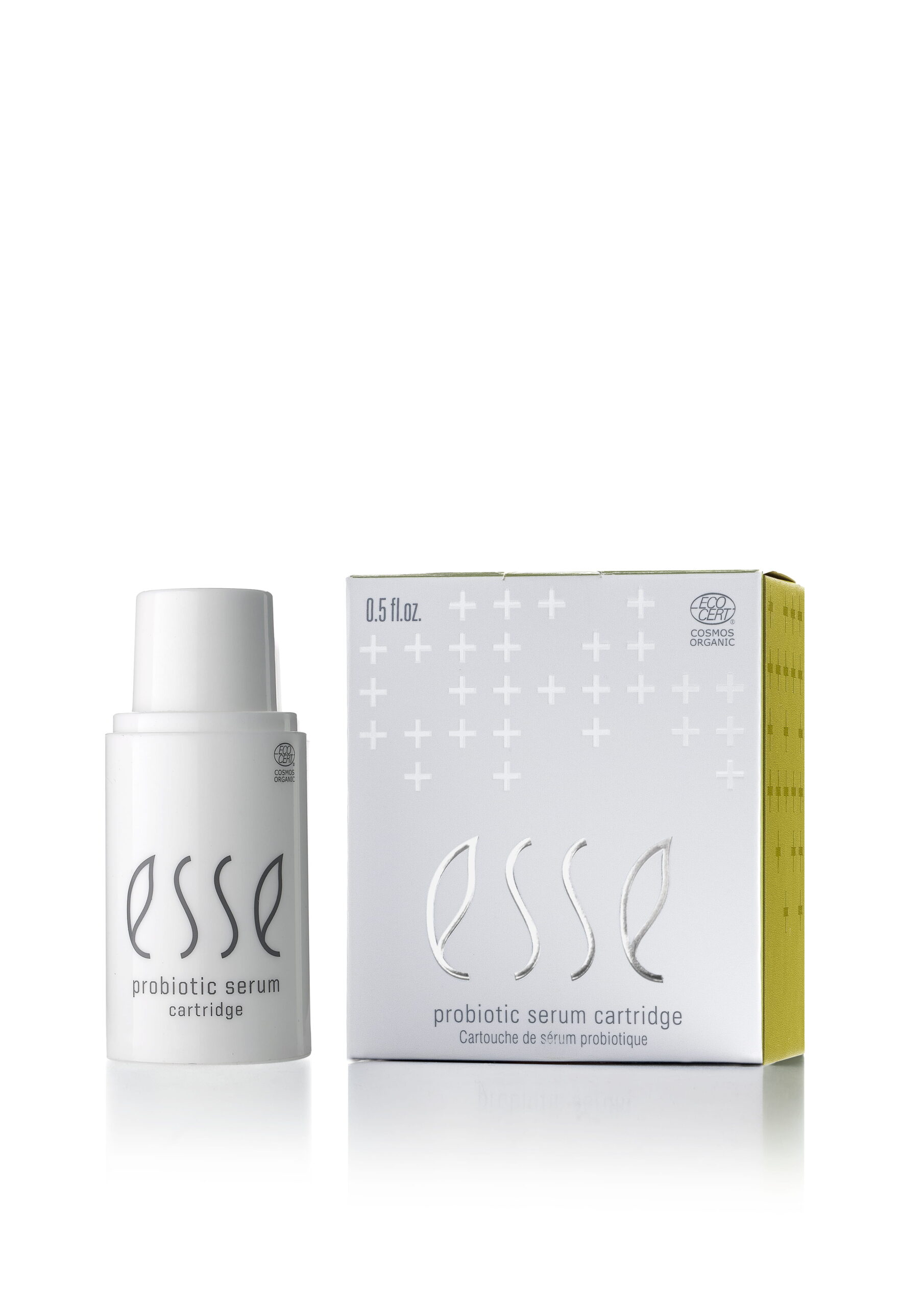 En vit flaska märkt "Esse Probiotic Serum" står bredvid sin matchande vita och gula låda, båda med varumärkets logotyp och plusteckensmönster.